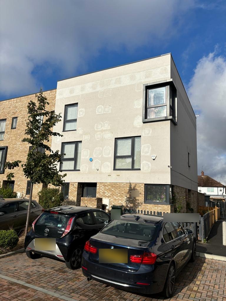 Rendered residential terrace in Carshalton showing made-good investigation openings across the elevation