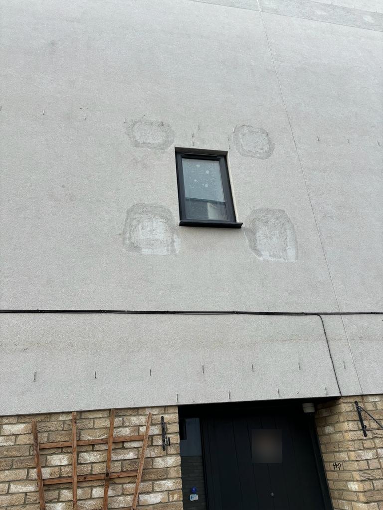 Made-good investigation openings either side of a window on a rendered residential terrace