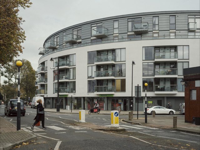 Curved residential building with grey rainscreen cladding to its upper floors